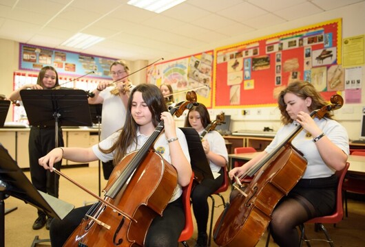 Cwmtawe pupils playing cello together in music class